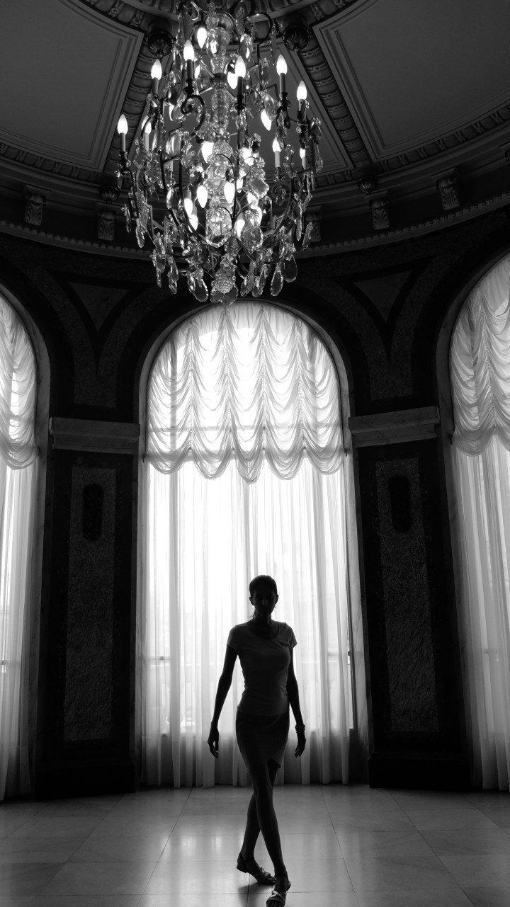 Stunning black and white image of the silhouette of a graceful dancer in the Casino Monte Carlo with chandelier
