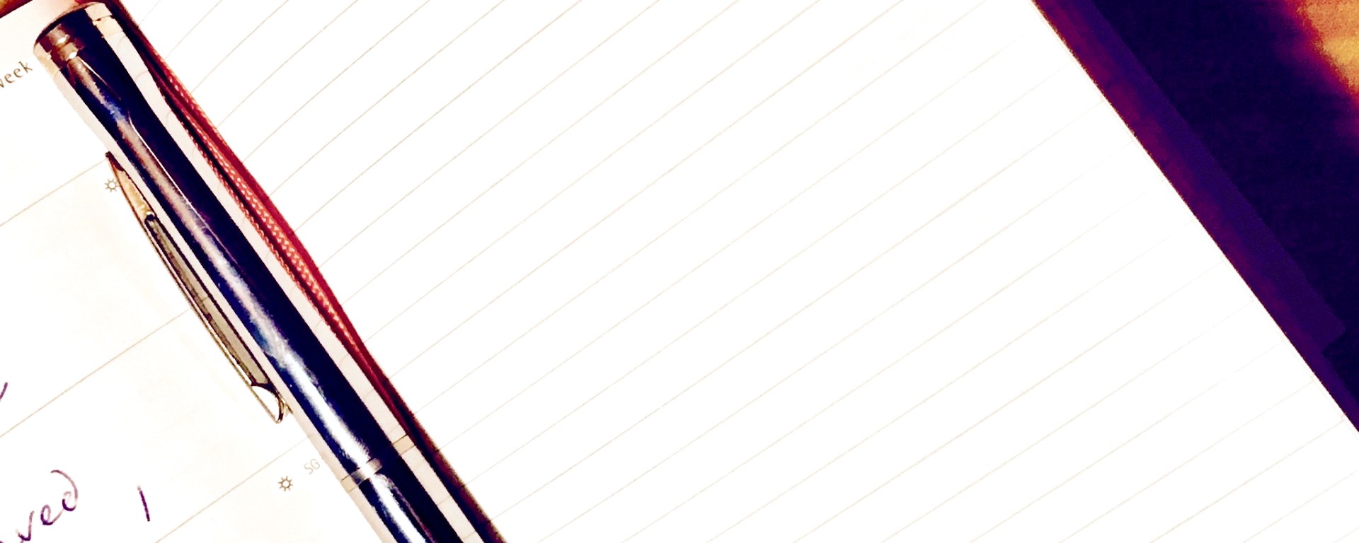 Closeup of an open notebook with a blank white page ready to be written in