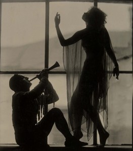 Beautiful photo of the silhouettes of a horn player and a dancer in front of a large window