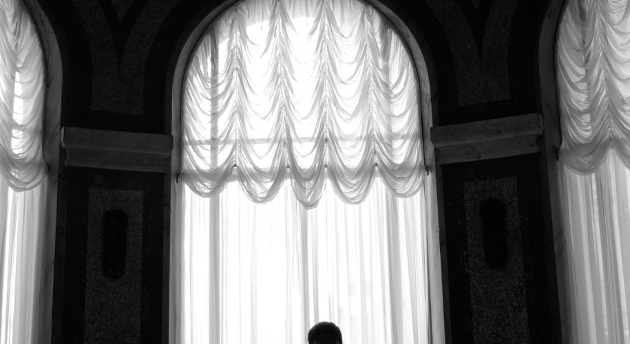 Black and white image of a slender dancer in silhouette gracefully walking toward the camera