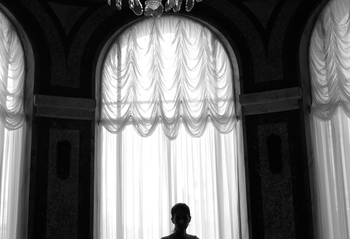 Black and white image of a slender dancer in silhouette gracefully walking toward the camera