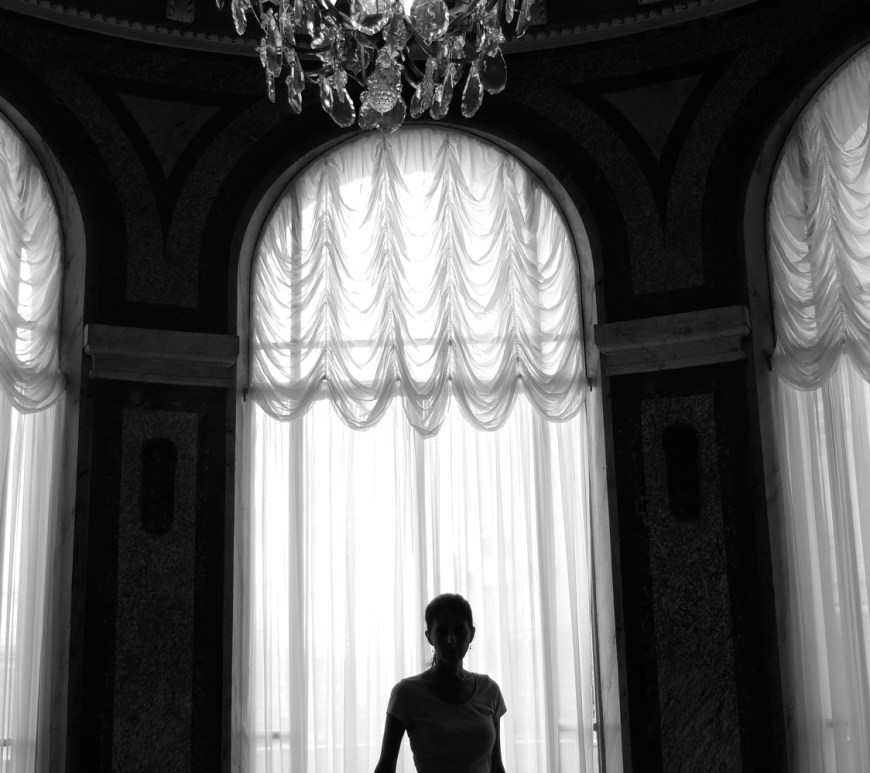 Black and white image of a slender dancer in silhouette gracefully walking toward the camera